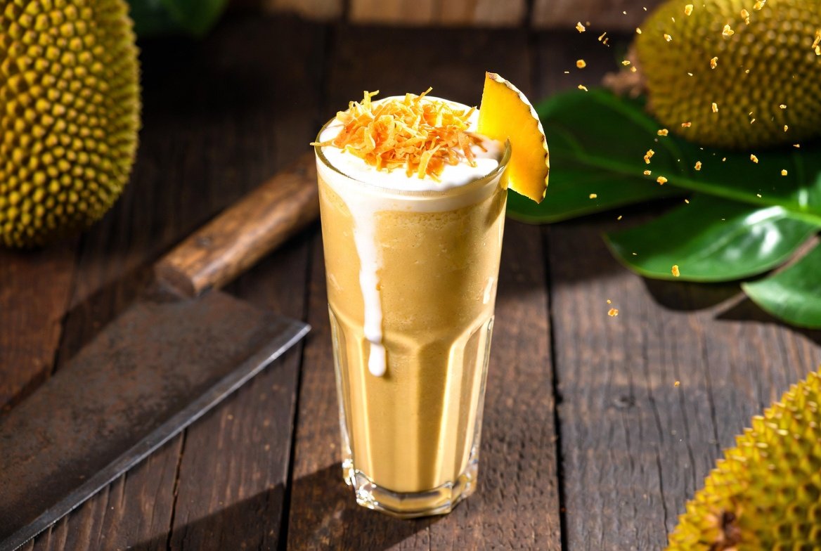 Milk Jeca pronto: milkshake cremoso de jaca madura com coco queimado e leite de coco, em copo alto estilo gourmet tropical.