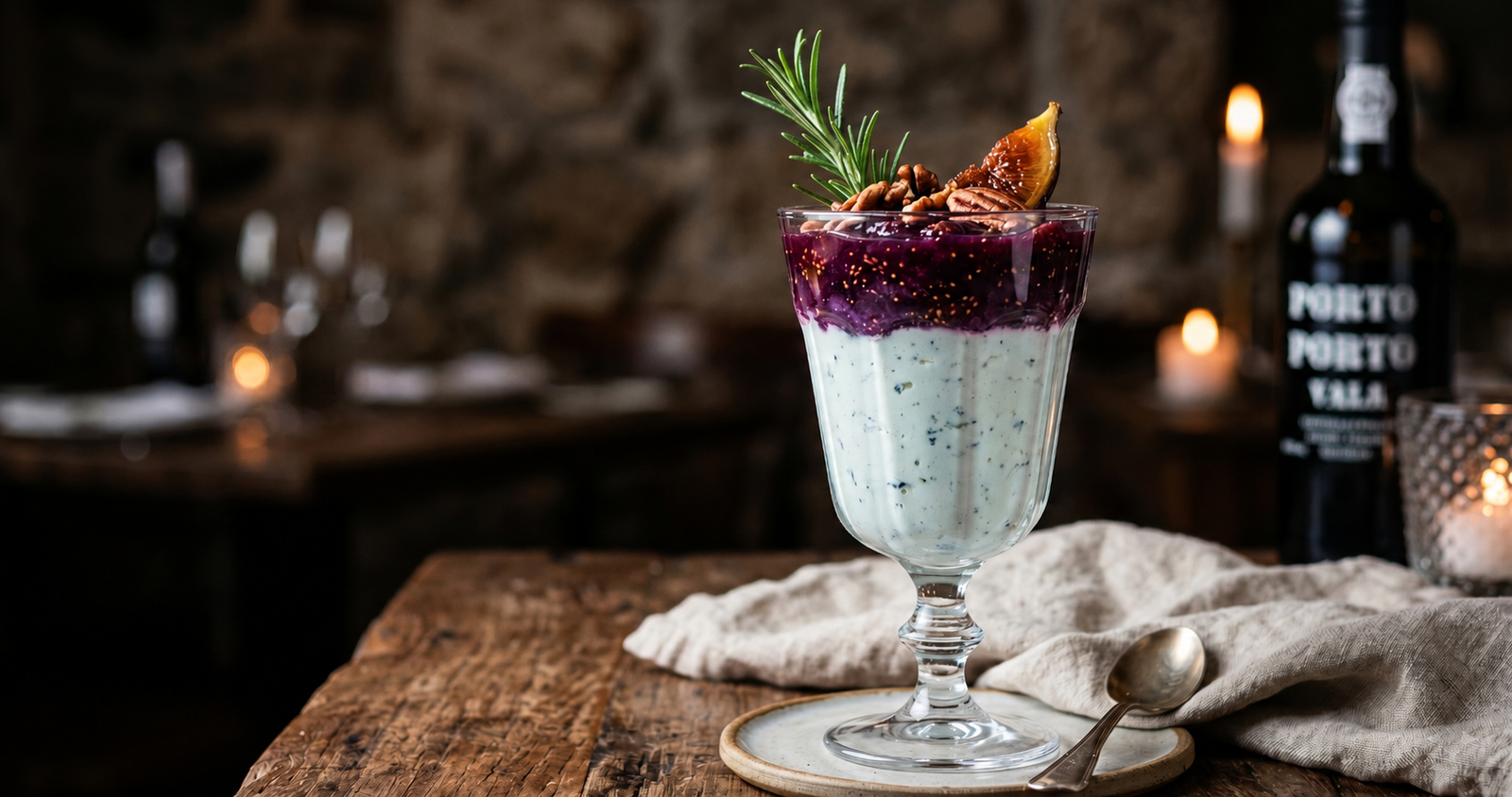 Taça de sobremesa com camadas de mousse de gorgonzola e geleia de figo rústica, decorada com nozes e alecrim em fundo escuro sofisticado.